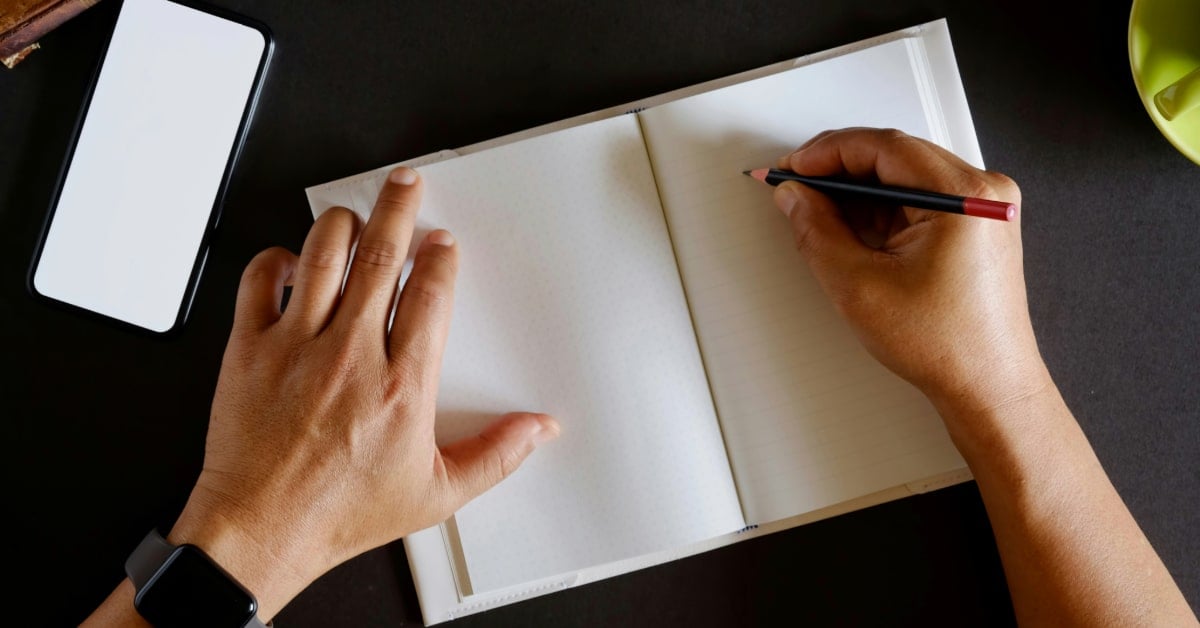 A man begins to write his novel in a blank notebook.
