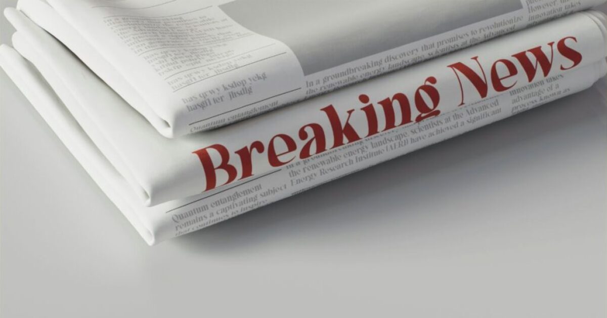 a stack of newspapers with red text