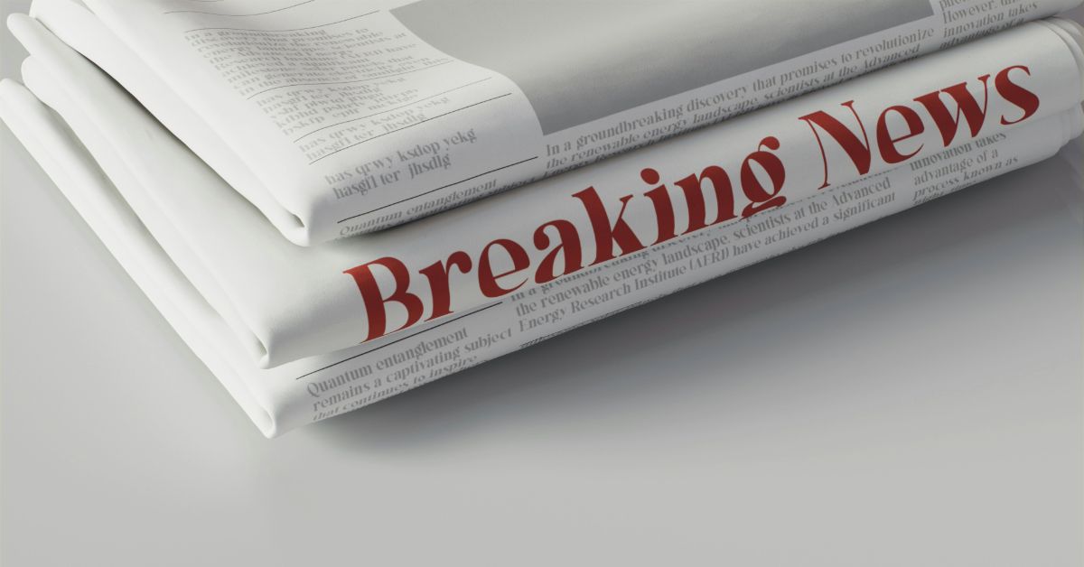 a stack of newspapers with red text