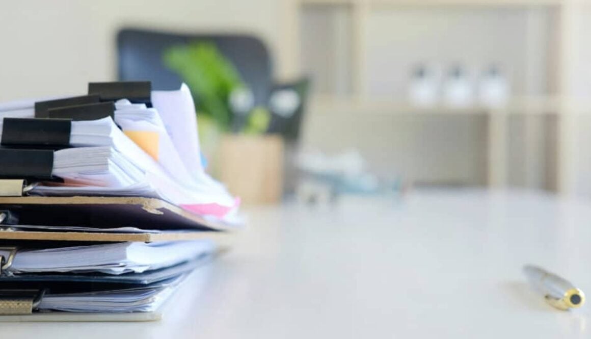 a stack of papers on clip boards and bound with binder clips on a desk