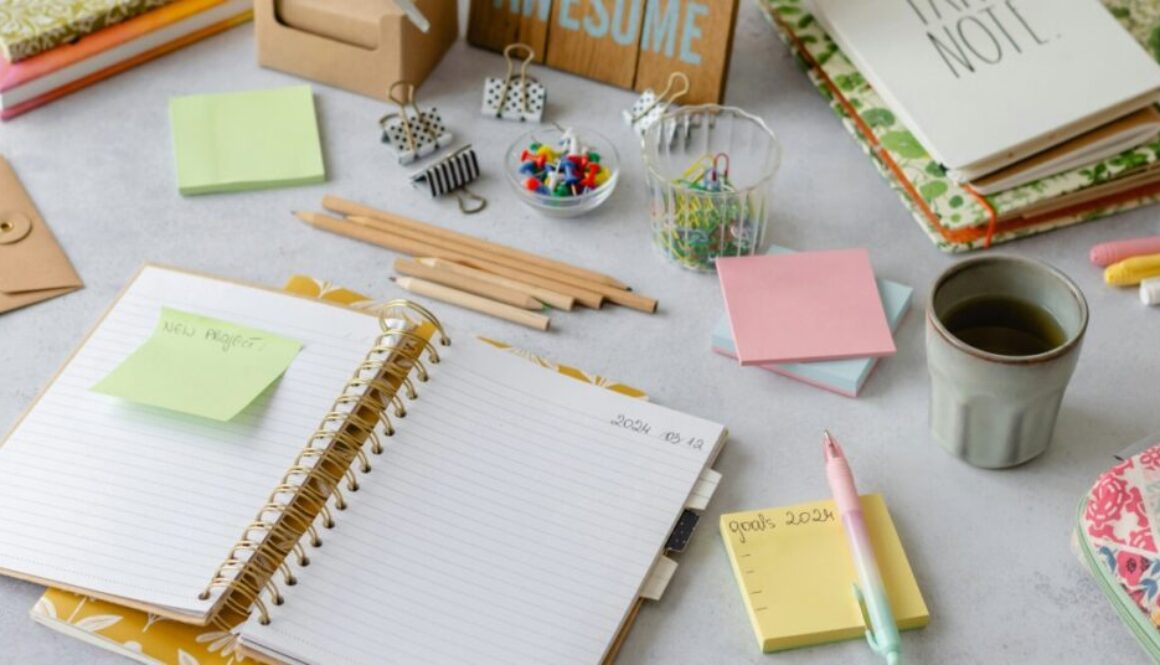 a notebook, paperclips, and other planning supplies and stationery on a table