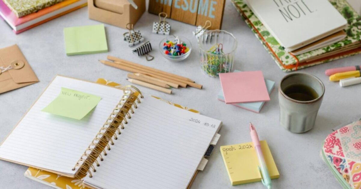 a notebook, paperclips, and other planning supplies and stationery on a table
