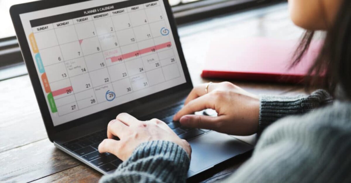 a person using a planner and calendar app on a laptop