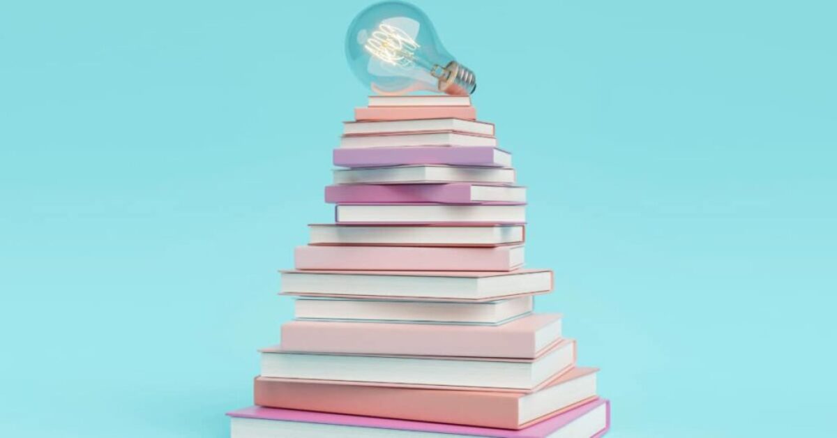 a lightbulb resting on a stack of books