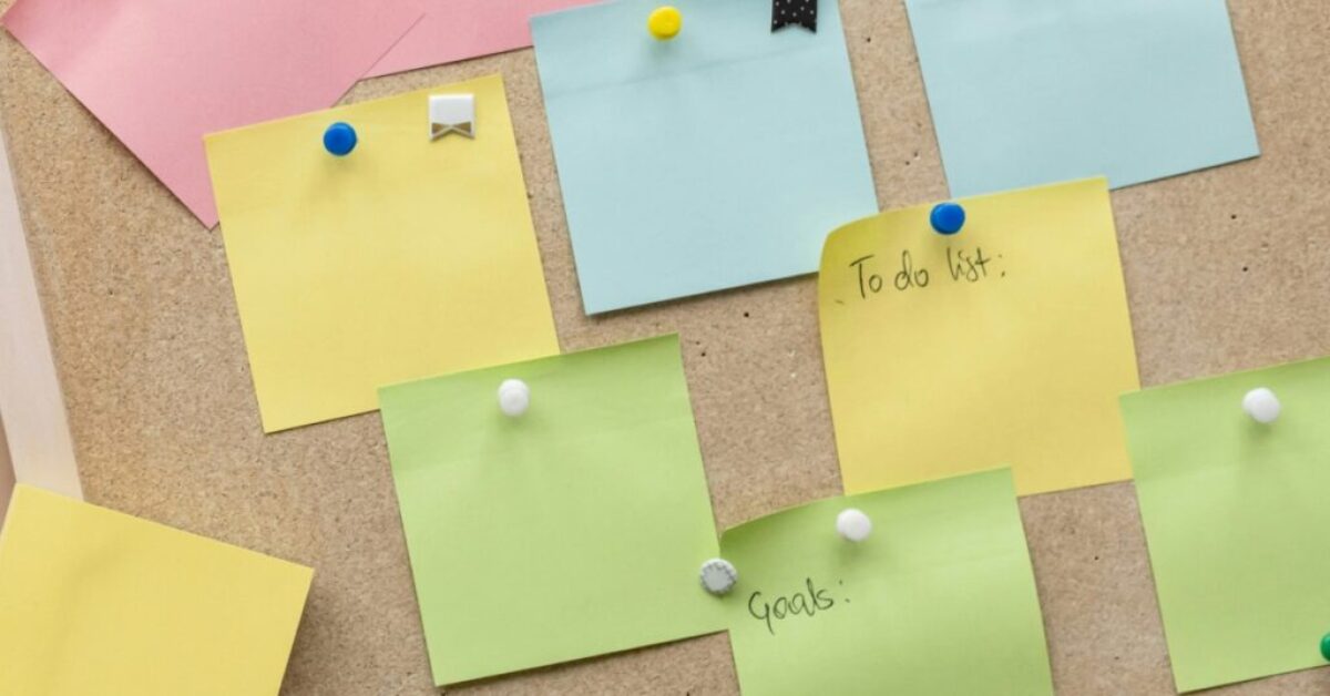 sticky notes thumbtacked to a bulletin board