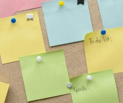 sticky notes thumbtacked to a bulletin board